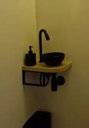 Moderne toilet renovatie met tegelwerk en design wastafel.jpg