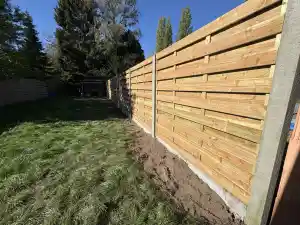    Afsluiting met betonpalen en houten schermen.jpg